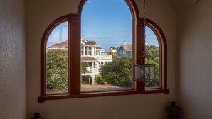 Una habitación con un amplio ventanal arqueado que da a un barrio residencial.