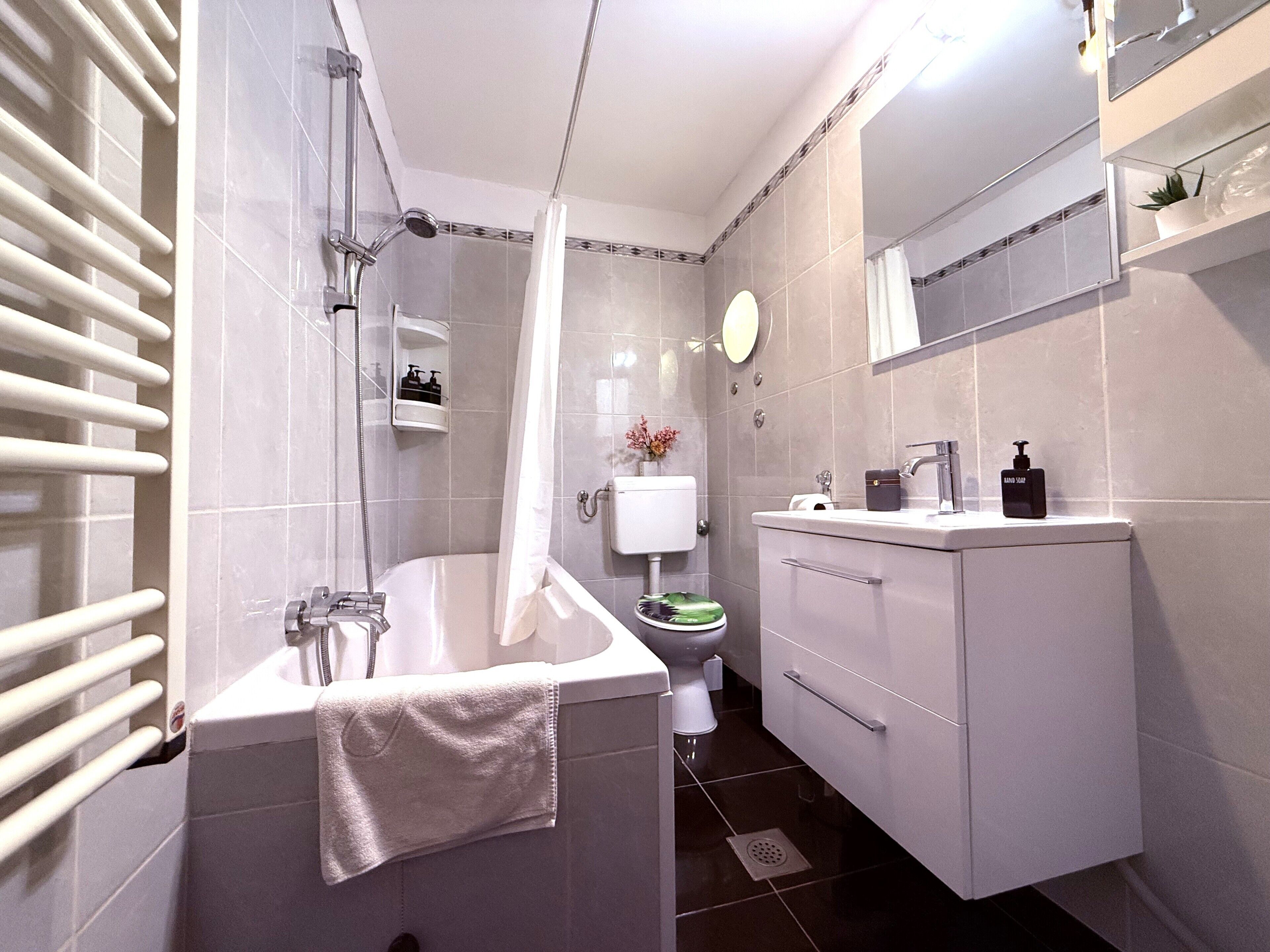 Une salle de bain moderne équipée d’une baignoire, de toilettes et d’un lavabo.