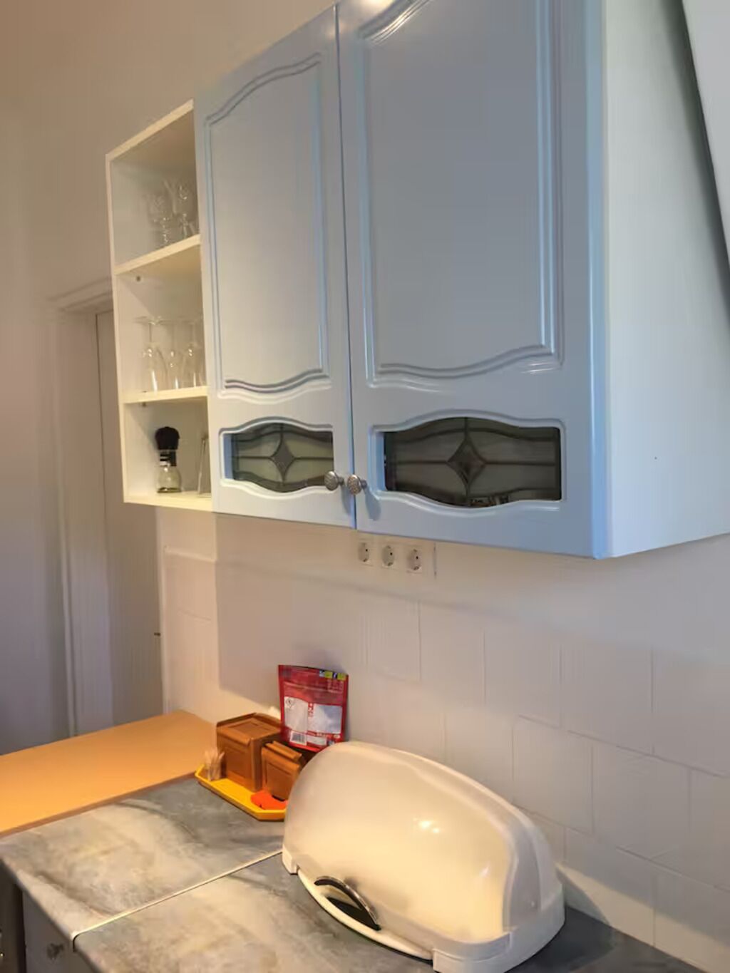 A kitchen with white cabinets, a countertop, and a toaster.
