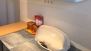 Una cocina con armarios blancos, una encimera y un tostador.