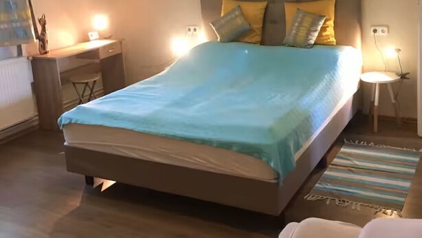 Un dormitorio moderno con una cama grande, un escritorio y una silla.