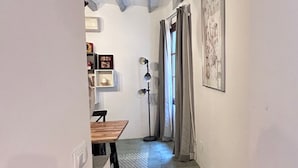 A narrow hallway with a wooden table and chairs, a floor lamp, and a framed artwork on the wall. - Solleric Petit Hotel (Sóller)