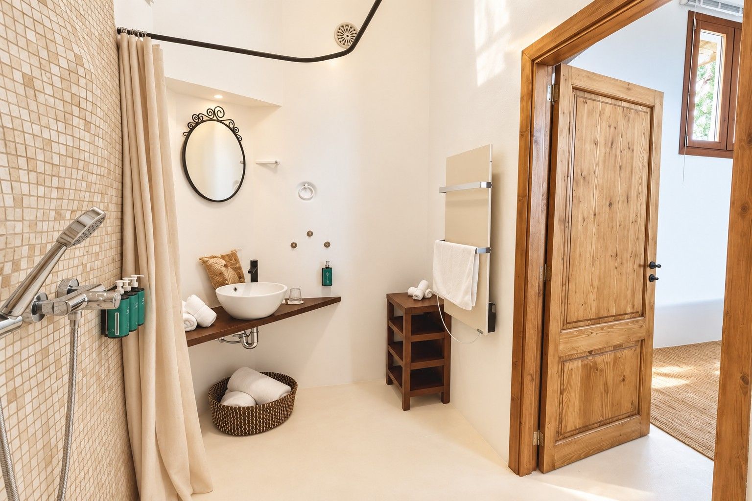 Een badkamer met douche, wastafel, spiegel, handdoekhouder en een houten deur.