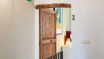 Une porte en bois à l’aspect rustique, un panneau vert indiquant la sortie de secours et un panneau mural portant le chiffre « 4 ».
