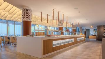 Eine moderne Hotelhalle mit einer zentralen Rezeption, Holzböden und großen Fenstern.