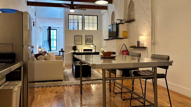 A modern kitchen with wooden beams, a dining area with a glass table, and a cozy living room with a sofa. - Modern Studio APT in the Heart of Downtown Geneva (Geneva)