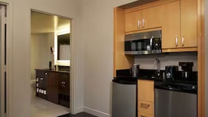 Une cuisine moderne dotée d’appareils électroménagers en acier inoxydable, de meubles en bois et d’un plan de travail noir.