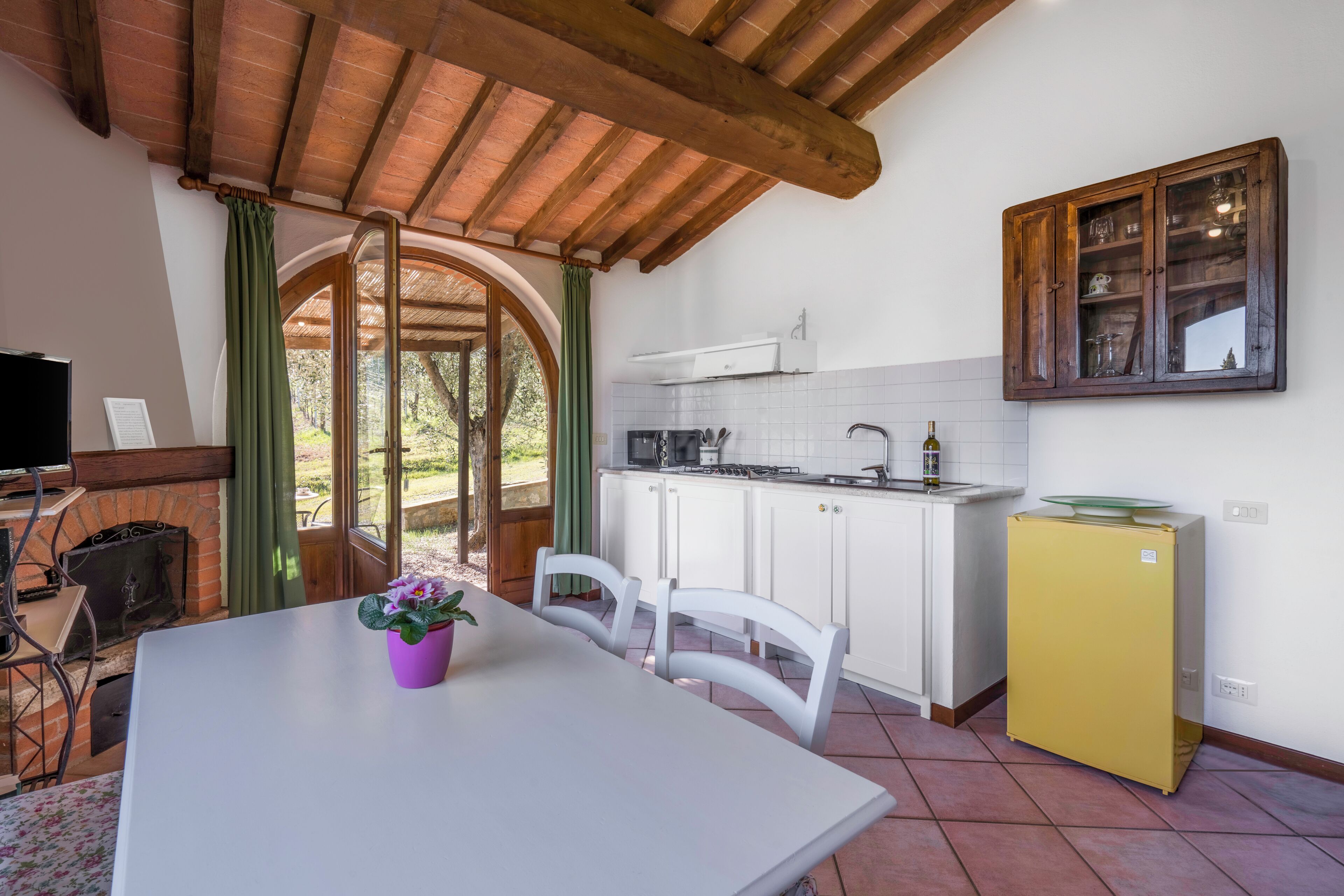A kitchen with white cabinets, a yellow refrigerator, and a wooden ceiling.