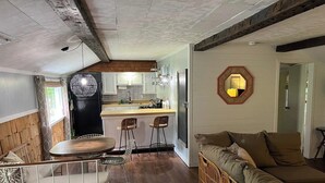 Un espace de vie compact comprenant une cuisine, un coin repas et un coin salon.