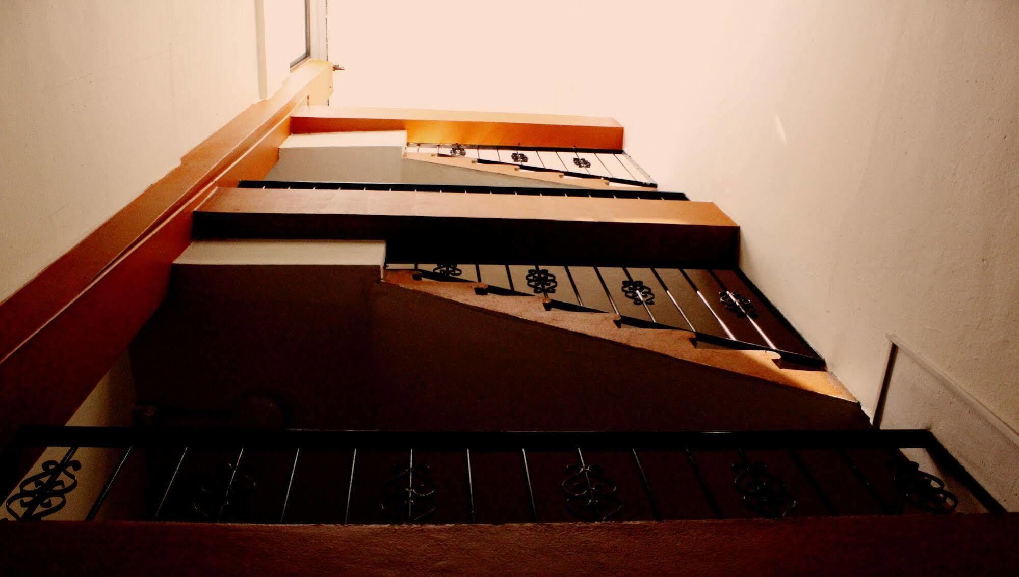 A staircase with a wooden handrail and a metal banister.