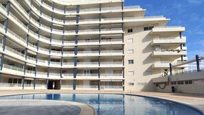 A multi-story hotel with a swimming pool.