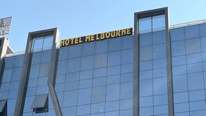 Un edificio moderno con el letrero "HOTEL MELBOURNE" en la fachada.