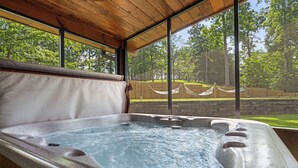 A hot tub with a view of a grassy area and trees. - You have to see Red Bird Lodge (SEVIERVILLE)