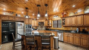 A spacious kitchen with wooden cabinets, a large island, and modern appliances. - You have to see Red Bird Lodge (SEVIERVILLE)