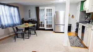 A compact living space with a dining area, kitchen, and a small entryway. - SOFIMA-Cozy and Charming 2-bedroom apartment! (Woburn)
