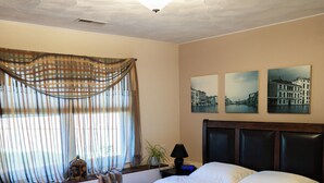 A neatly made bed with white linens and towels, a dark wooden headboard, and a window with sheer curtains. - SOFIMA-Cozy and Charming 2-bedroom apartment! (Woburn)