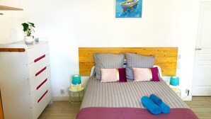 A bedroom with a bed, a dresser, a nightstand, a lamp, and a painting on the wall. - [1] Blue Summer Vibes Apartment, Air-conditioned, Parking, Beach 50m away, SPA access (La Ciotat)
