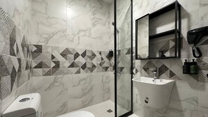 A modern bathroom with a toilet, sink, and glass shower enclosure. - M-Residence by Dayf Self-Service Apart. (Jeddah)