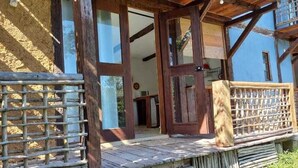 Een houten gebouw in rustieke stijl met een houten veranda en een lattenhek.
