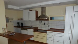 A kitchen with white cabinets, a stainless steel sink, and a wooden countertop. - Spacious vacation apartment for families, fitters, cyclists, Legoland (Günzburg)