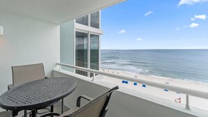 A balcony with a table and chairs, overlooking a beach with a railing and a view of the ocean. - Perdido Sun 800 (Pensacola)
