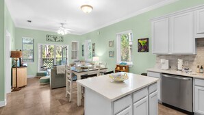 A spacious kitchen with white cabinets, a central island, and a dining area with a table and chairs. - New Listing! 30A Condo Close to Beach, Shopping and Dining! (Santa Rosa Beach)