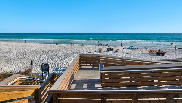 A beach with a wooden boardwalk leading to the water, a lifeguard tower, and beach chairs. - New Listing! 30A Condo Close to Beach, Shopping and Dining! (Santa Rosa Beach)