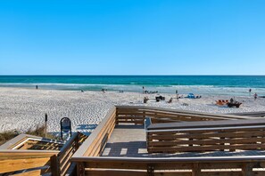 A beach with a wooden boardwalk leading to the water, a lifeguard tower, and beach chairs. - New Listing! 30A Condo Close to Beach, Shopping and Dining! (Santa Rosa Beach)