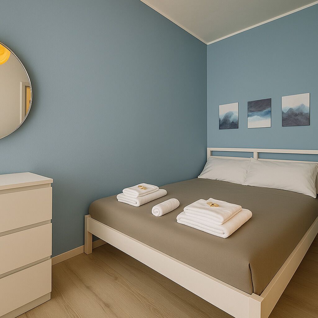 Une chambre à coucher avec un lit, une commode et trois tableaux encadrés accrochés au mur.