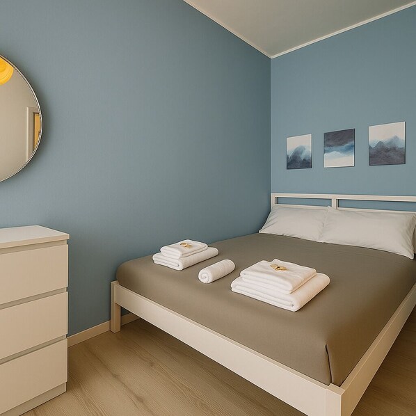 Une chambre à coucher avec un lit, une commode et trois tableaux encadrés accrochés au mur.