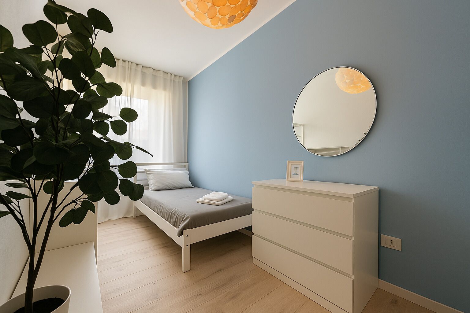 A bedroom with a bed, dresser, mirror, and a potted plant.