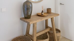 A wooden console table with a mirror, a vase, and two baskets. - ROCK BAY II 2283 STUNNING VIEWS (Manilva)
