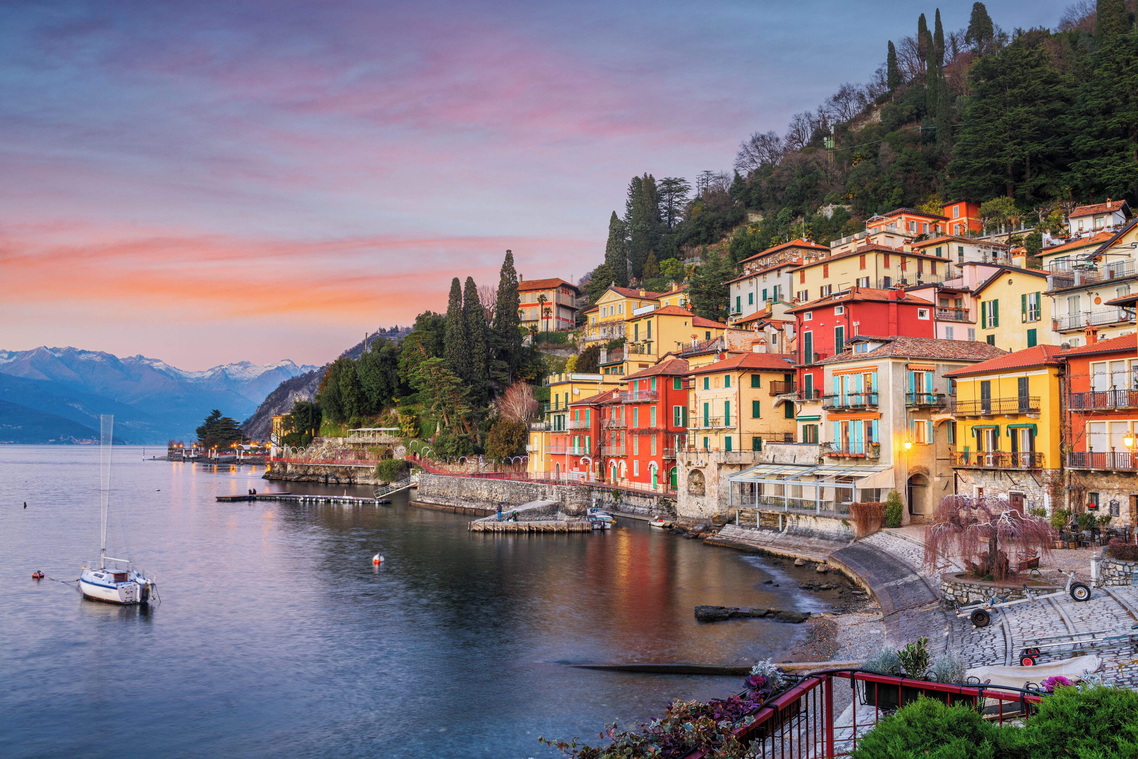 A waterfront town with colorful buildings, a dock, and a calm lake.