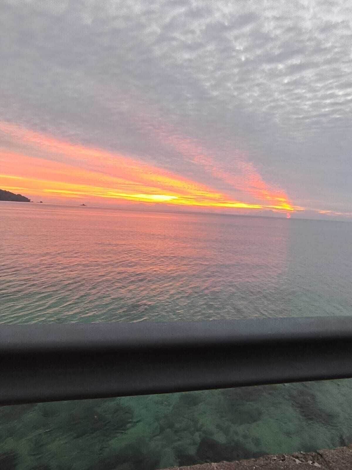 A sunset over a calm sea with a clear horizon.