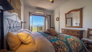 A bedroom with a bed, a dresser, a mirror, and a balcony with a view. - Boutique B&B Casa La Calera 15+/ Caminito del Rey-15 min/Ronda-25 min/Town-5 min (Teba)