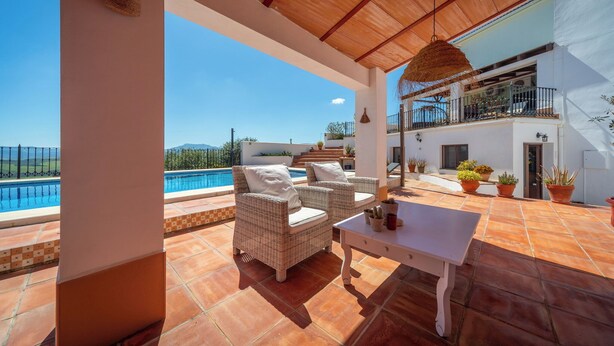 A terrace with wicker furniture, a pool, and a view of the landscape. - Boutique B&B Casa La Calera 15+/ Caminito del Rey-15 min/Ronda-25 min/Town-5 min (Teba)