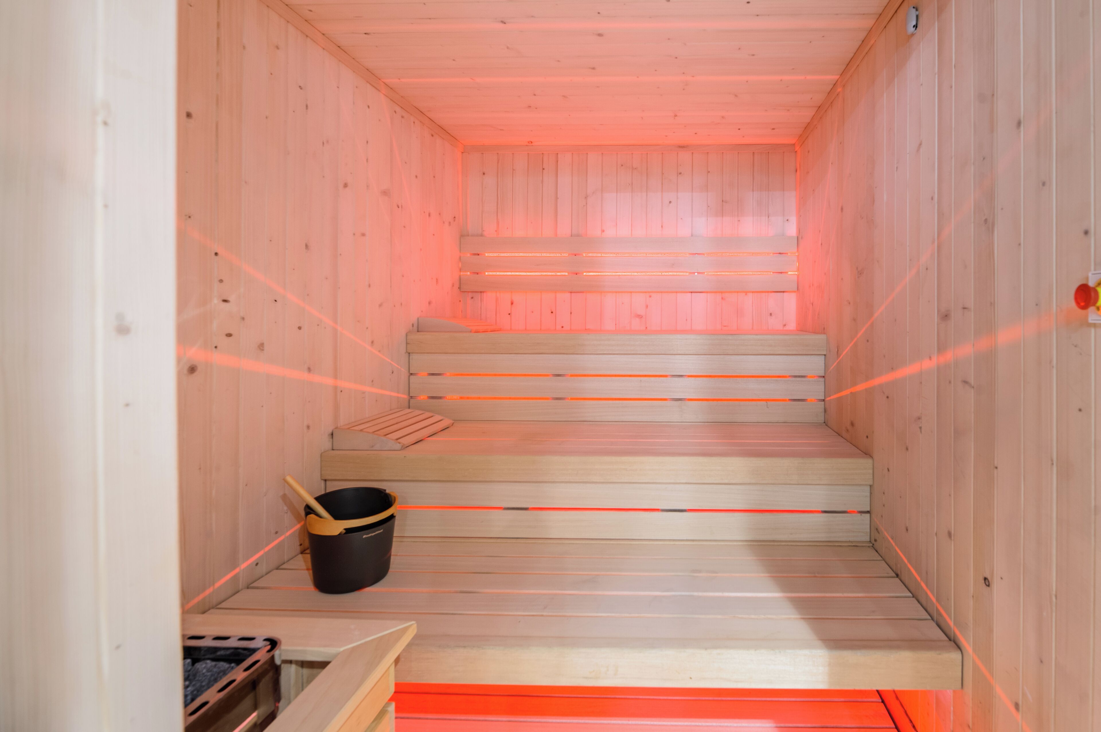 Una sauna con paredes de madera y un banco.