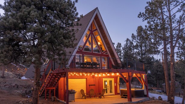 Une cabane dotée d’une grande terrasse à l’avant, d’un porche couvert et d’un bain à remous.