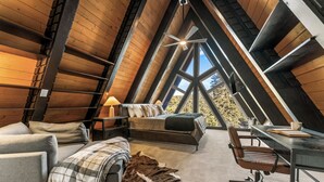 Une chambre mansardée chaleureuse, avec un lit, un bureau et une chaise.