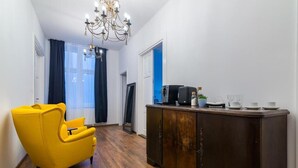 Una sala de estar moderna con un sillón amarillo, un mueble de madera oscura y una araña.