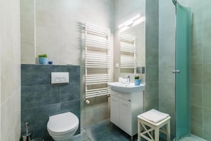 A modern bathroom with a toilet, sink, and shower.