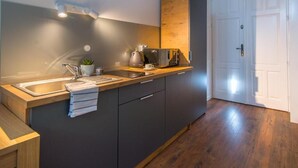 Una cocina moderna con encimera de madera, un lavamanos y una cafetera.