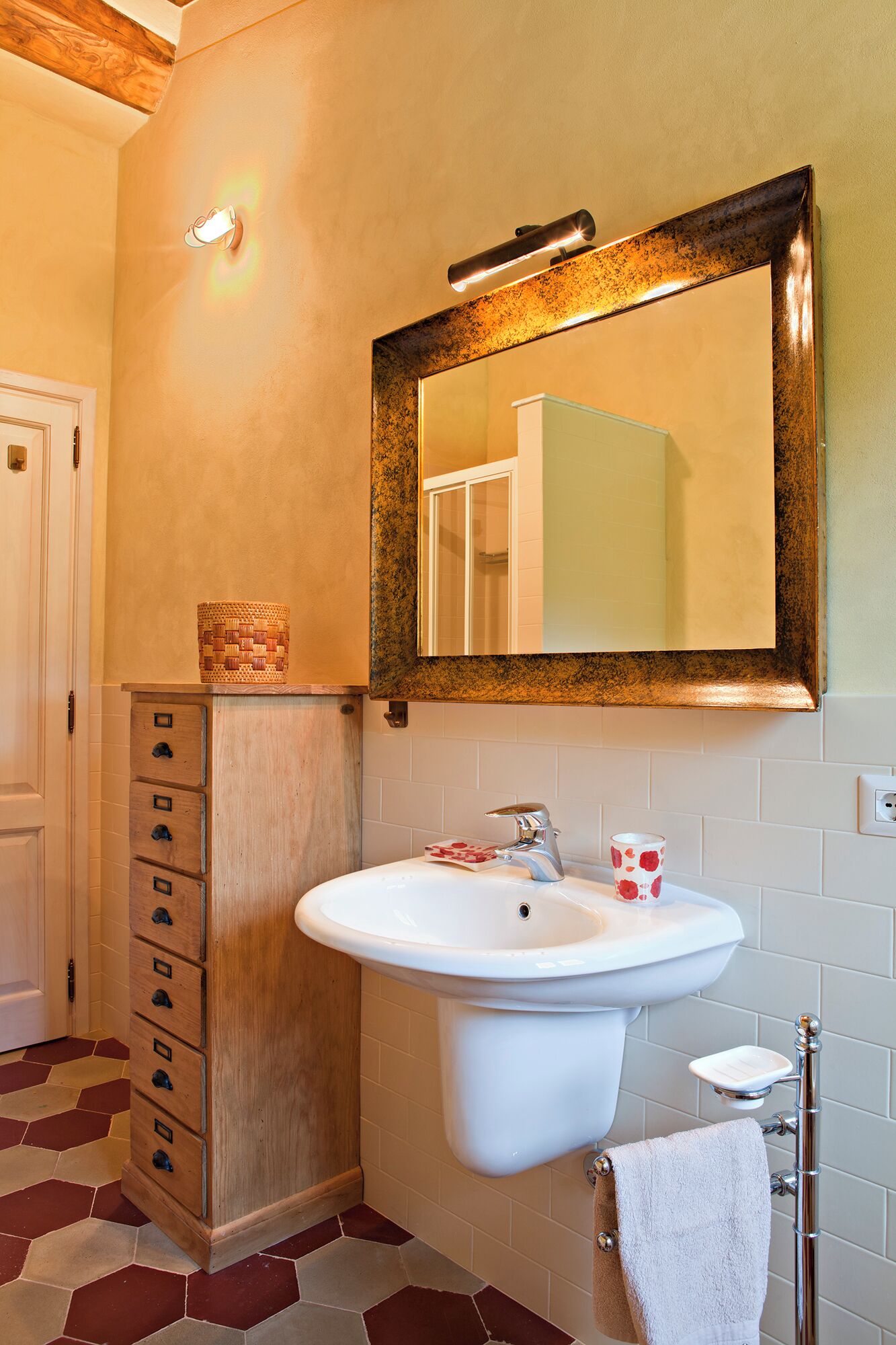 A bathroom with a white sink, a mirror, and a wooden cabinet.