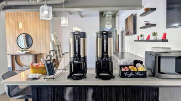 A coffee bar with two espresso machines, a coffee dispenser, and a coffee bar sign.