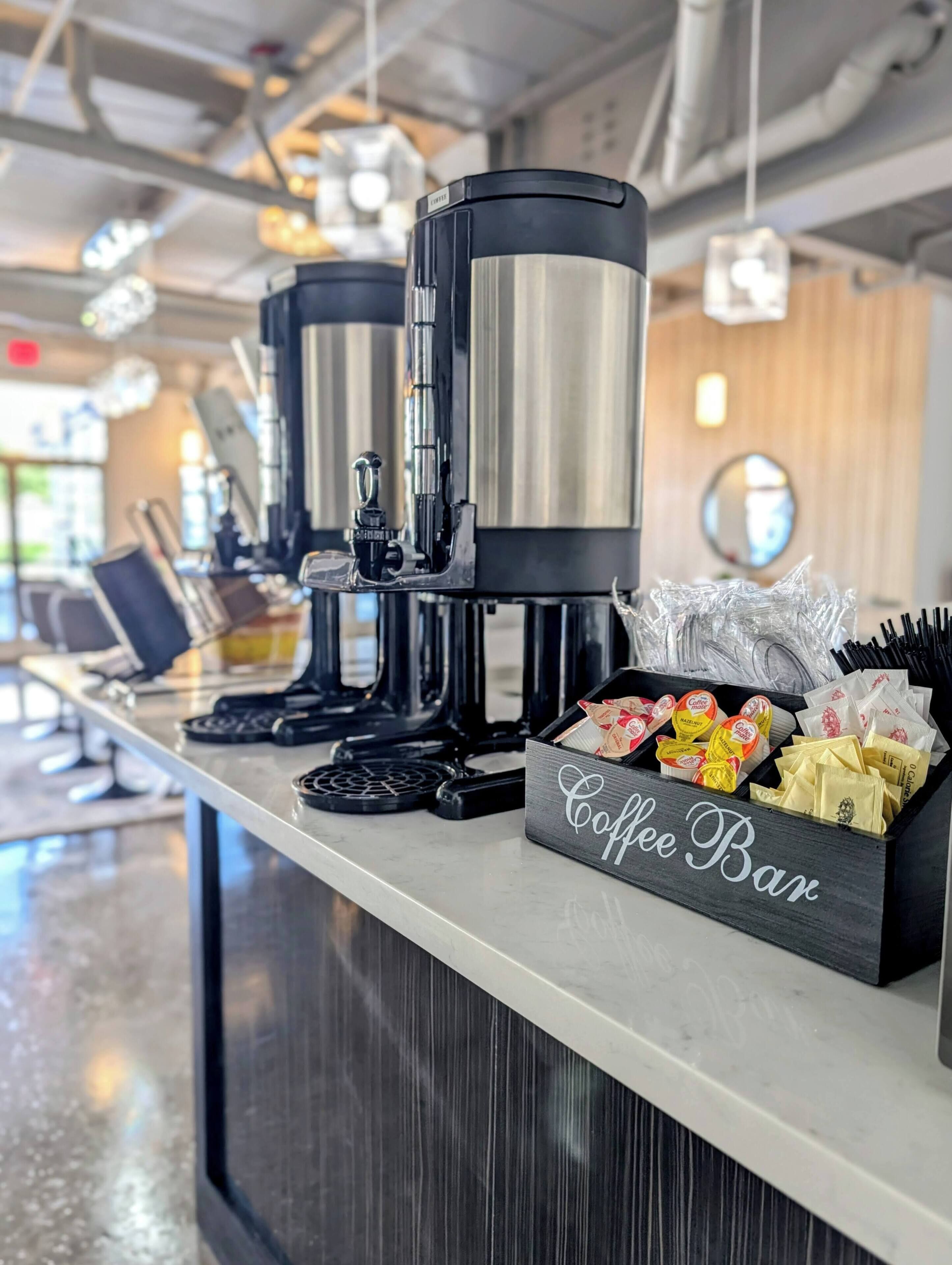 A coffee bar with espresso machines and a variety of coffee pods and syrups.