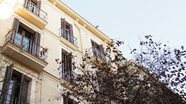 Um edifício com várias andares, varandas e janelas.