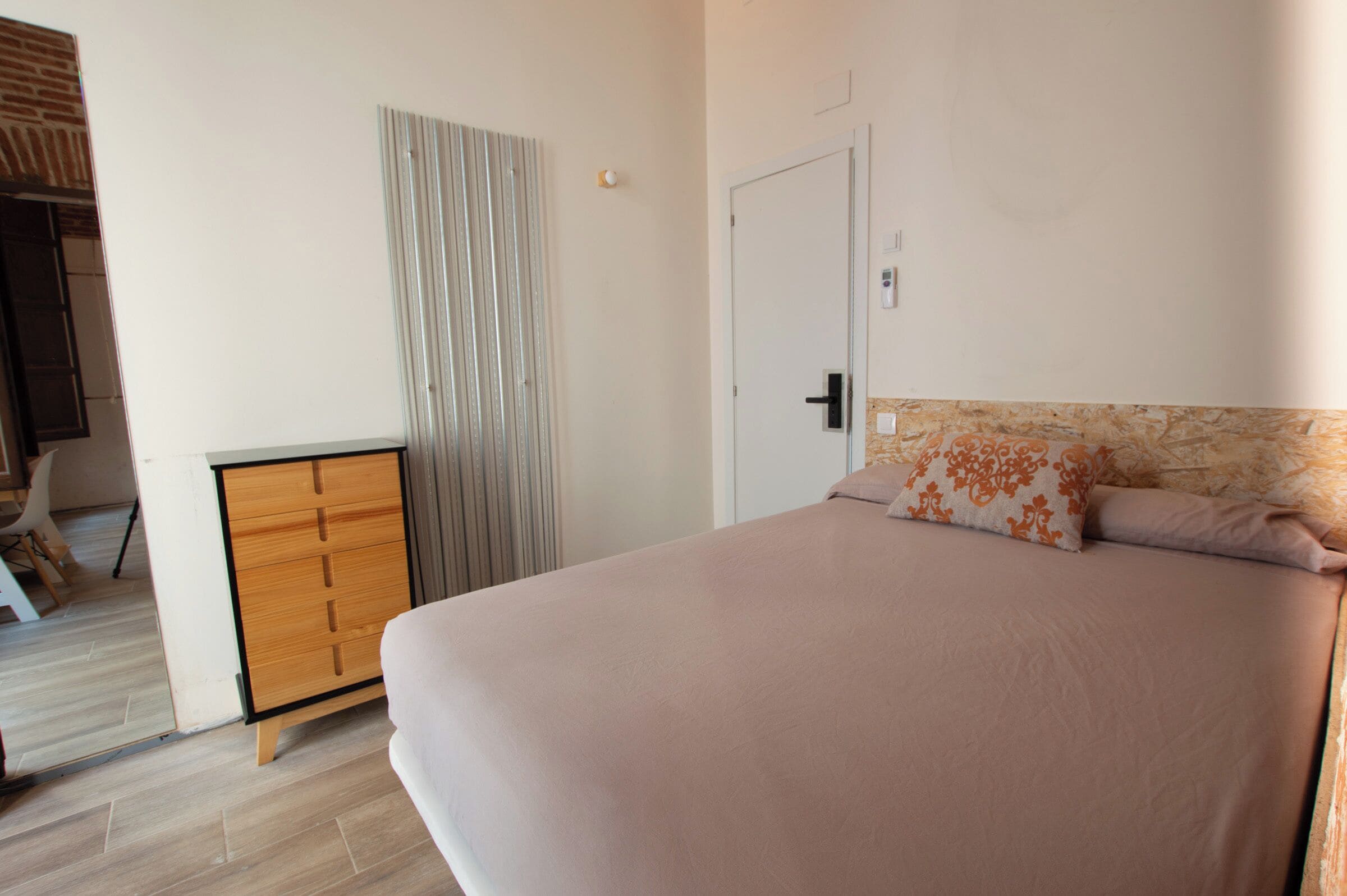 Ein Schlafzimmer mit einem Bett, einem Kleiderschrank und einer Tür.