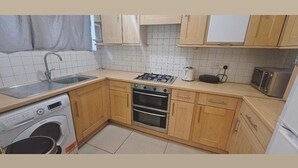 Una cucina compatta con lavatrice, fornello, forno e microonde.