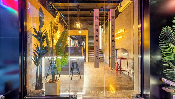 Ein modernes Interieur mit einer Rezeption, Topfpflanzen und einer Treppe zu oberen Etagen.