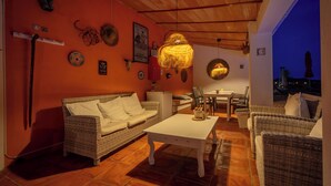 A cozy room with wicker furniture, a white table, and a hanging light fixture. - Boutique B&B Casa La Calera 15+/ Caminito del Rey-15 min/Ronda-25 min/Town-5 min (Teba)